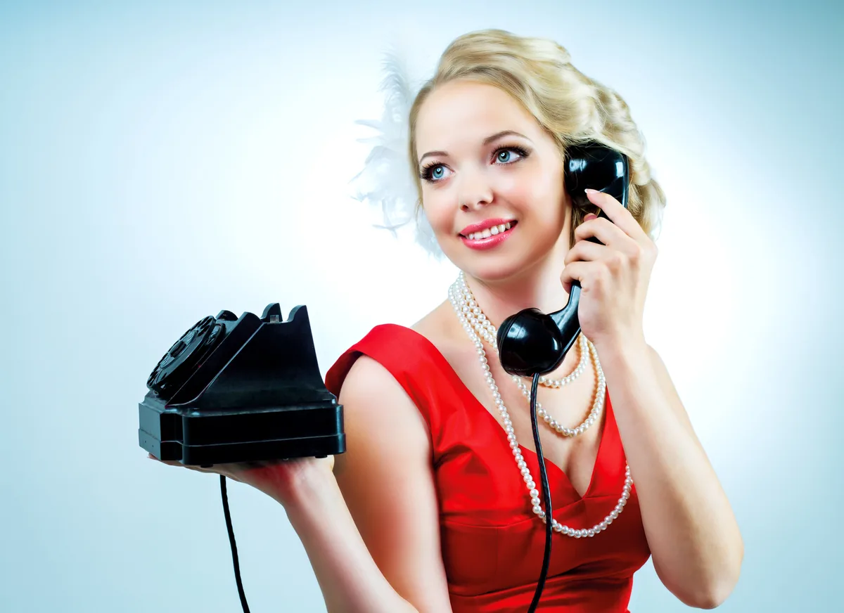 Blonde rétro en robe rouge, téléphone à cadran — ligne directe téléphone rose